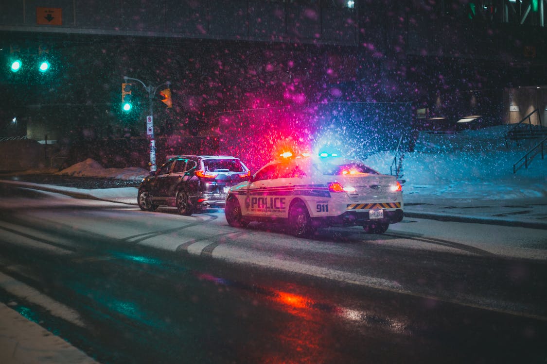 Foto de Erik Mclean en Pexels - Coche de policía en carretera de noche tras accidente de tráfico